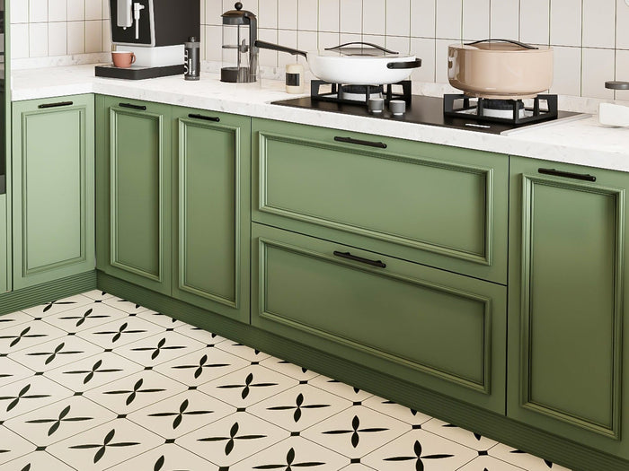 Modern kitchen with green and white cabinets, stainless steel appliances, and a geometric floor pattern.